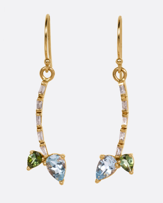 A pair of yellow gold dangle earrings with baguette diamond stems and green and blue tourmalines, shown from the front.