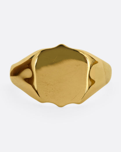 A yellow gold shield shaped signet ring. Shown from the front.
