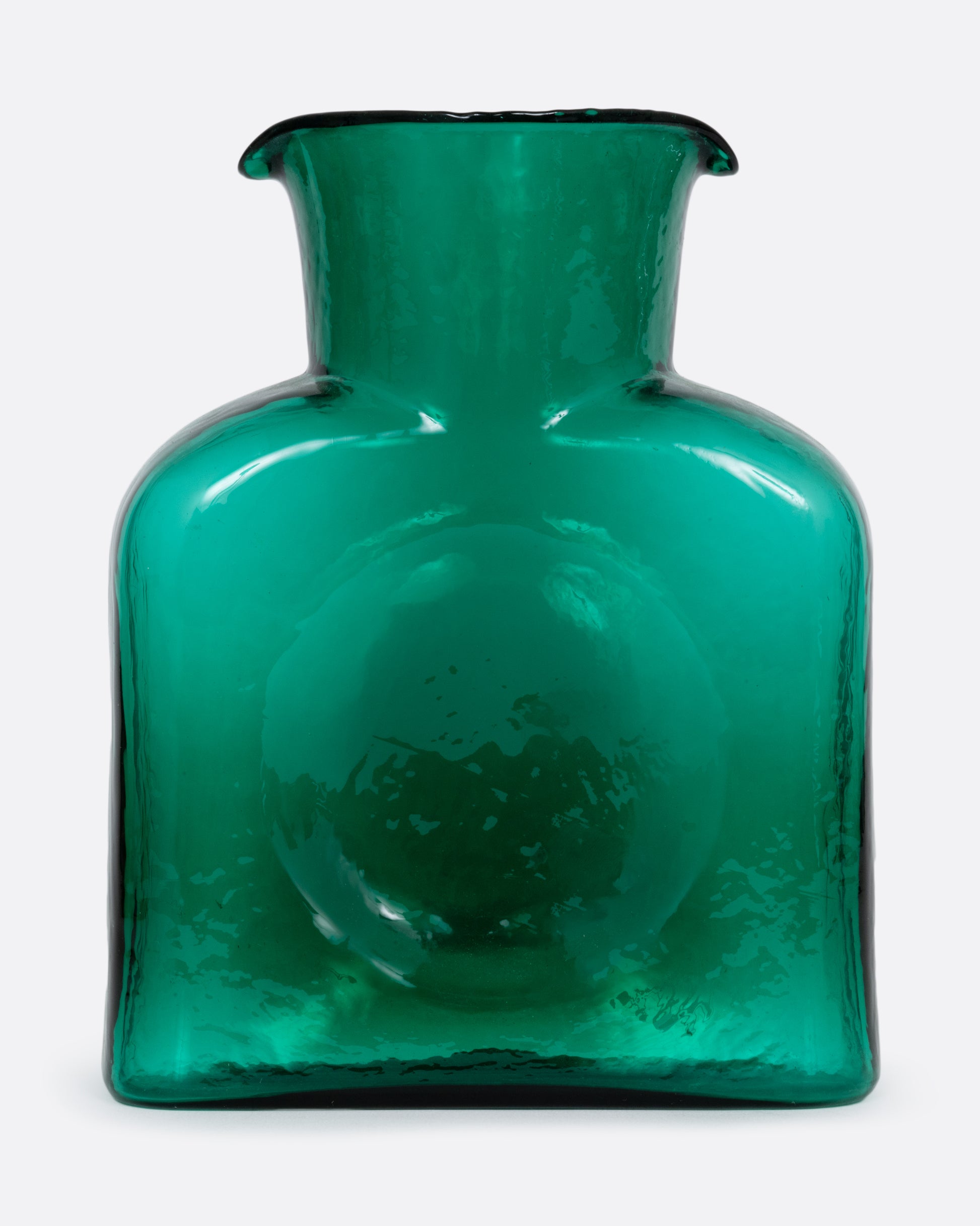A green glass double spouted 'water bottle' from Blenko. Shown from the front.
