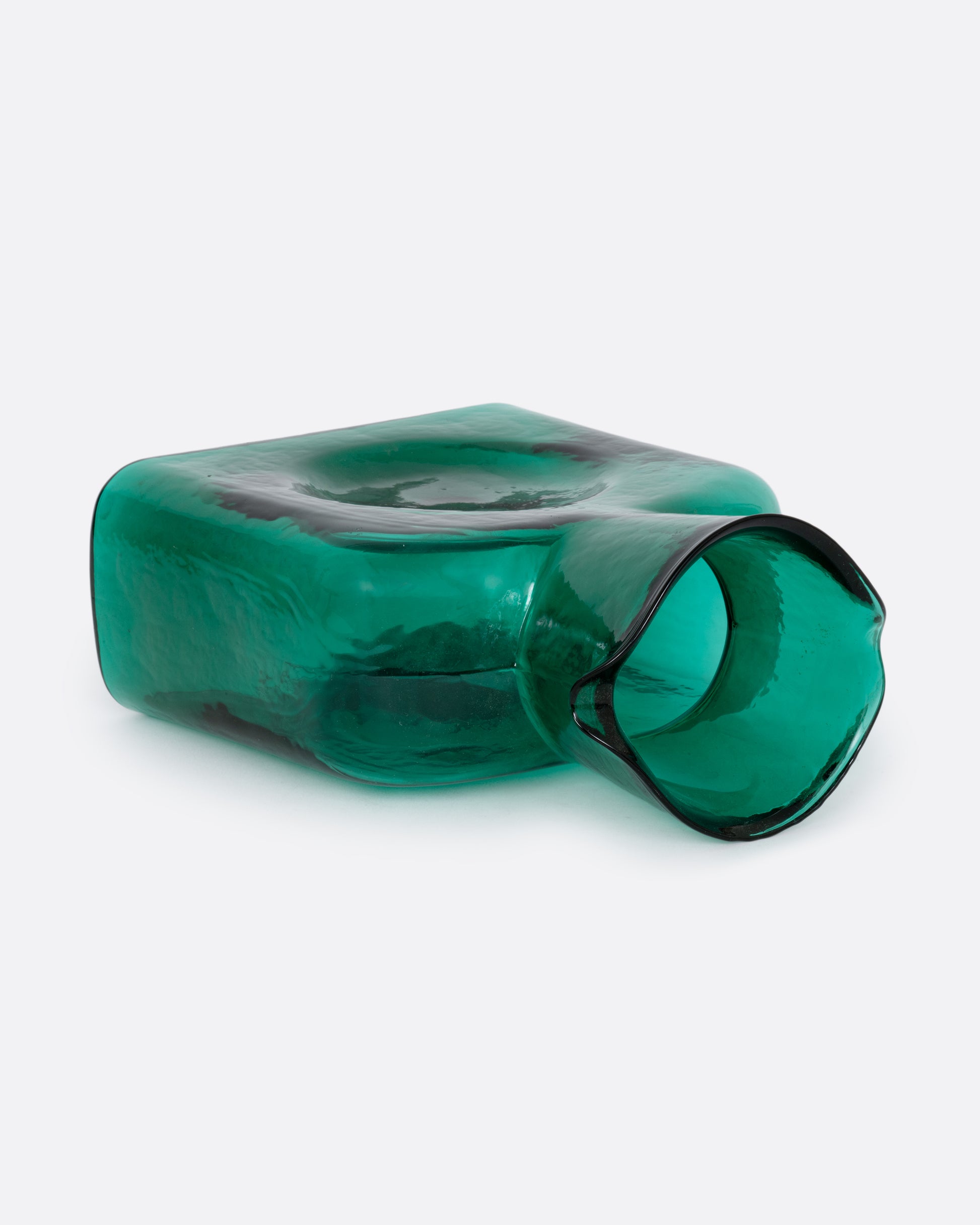 A green glass double spouted 'water bottle' from Blenko. Shown lying on its side from the top.