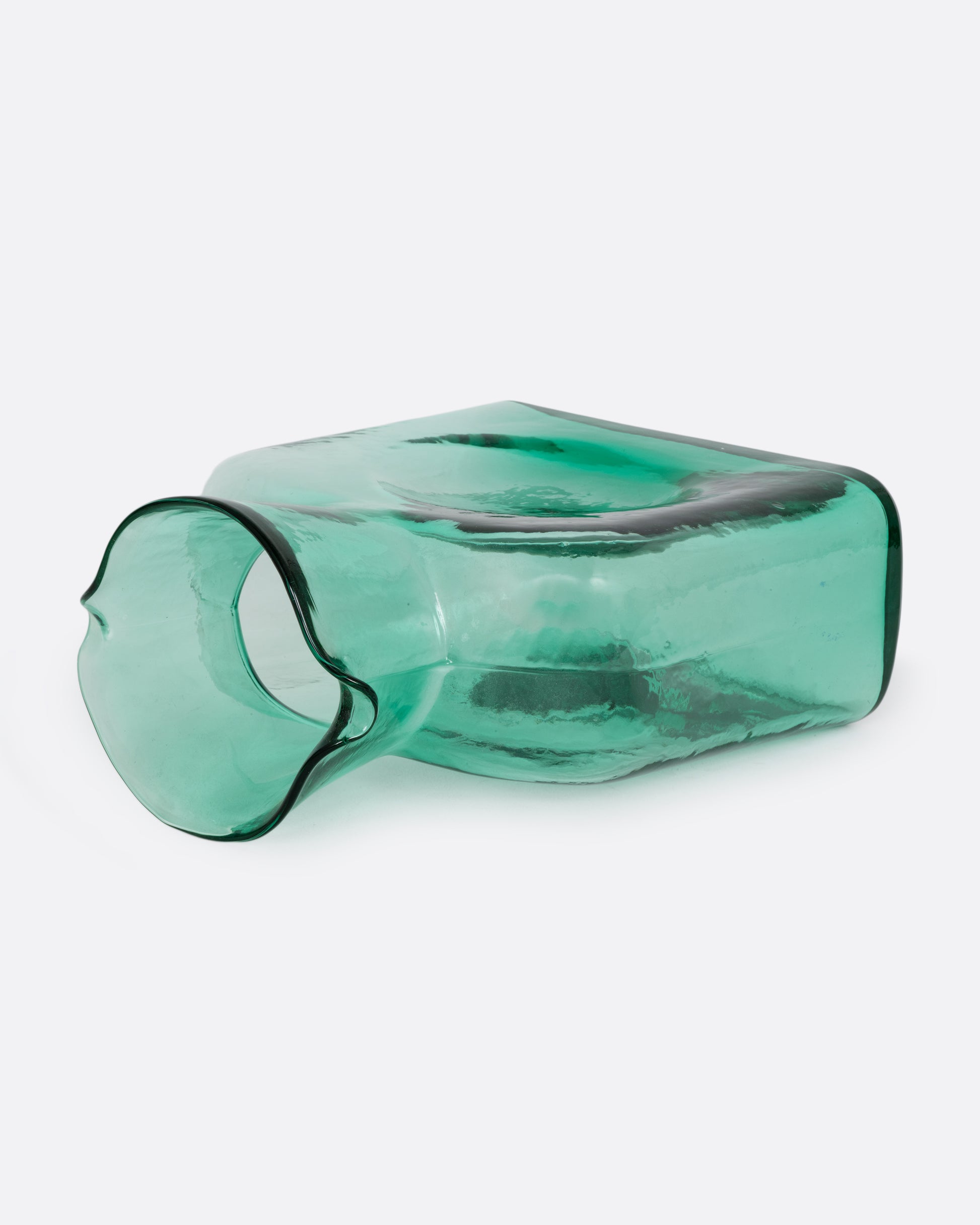 A green gradient glass double spouted 'water bottle' from Blenko. Shown lying on its side from the side.