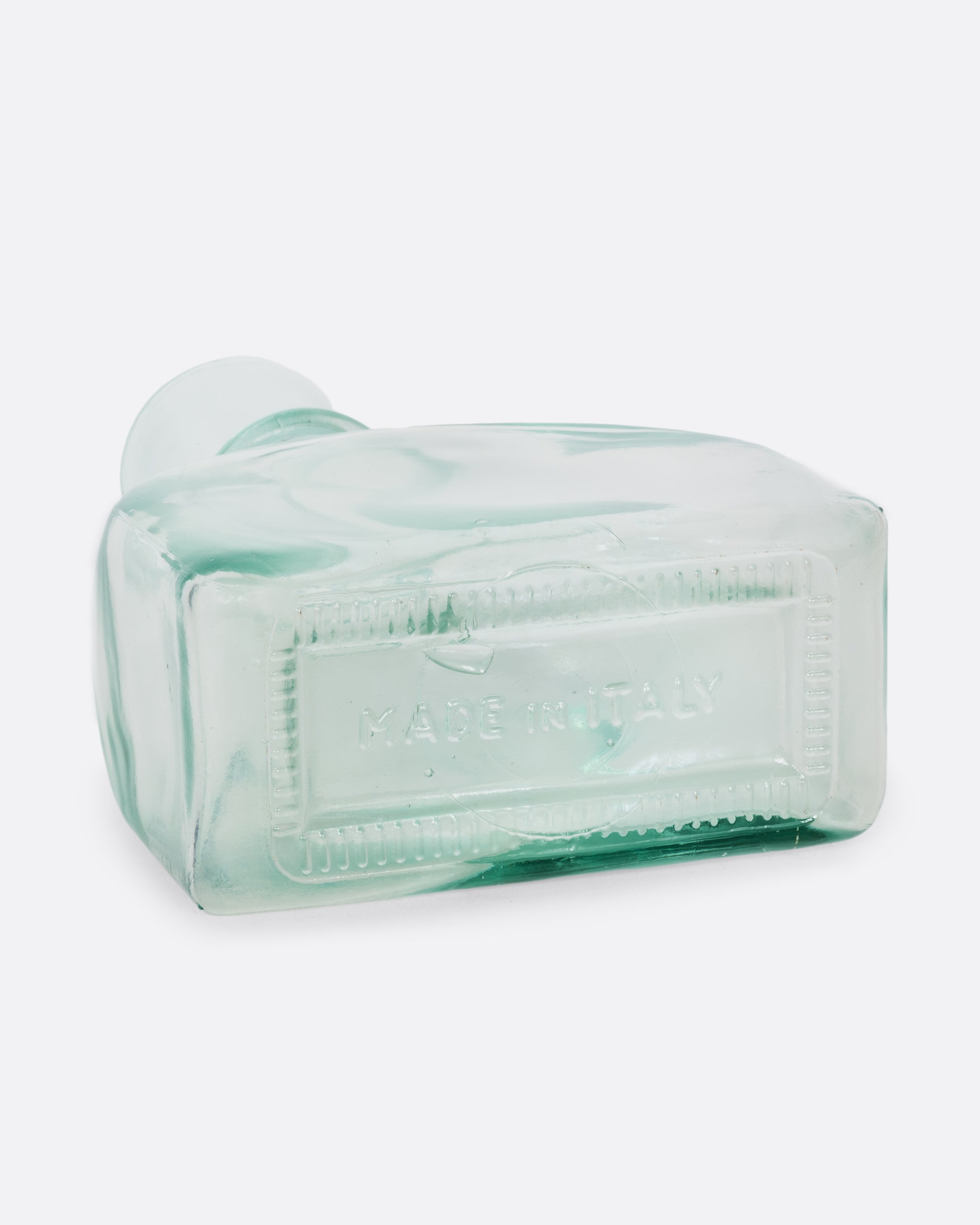 A clear glass decanter with a sphere shaped top. Shown lying on its side from the bottom.