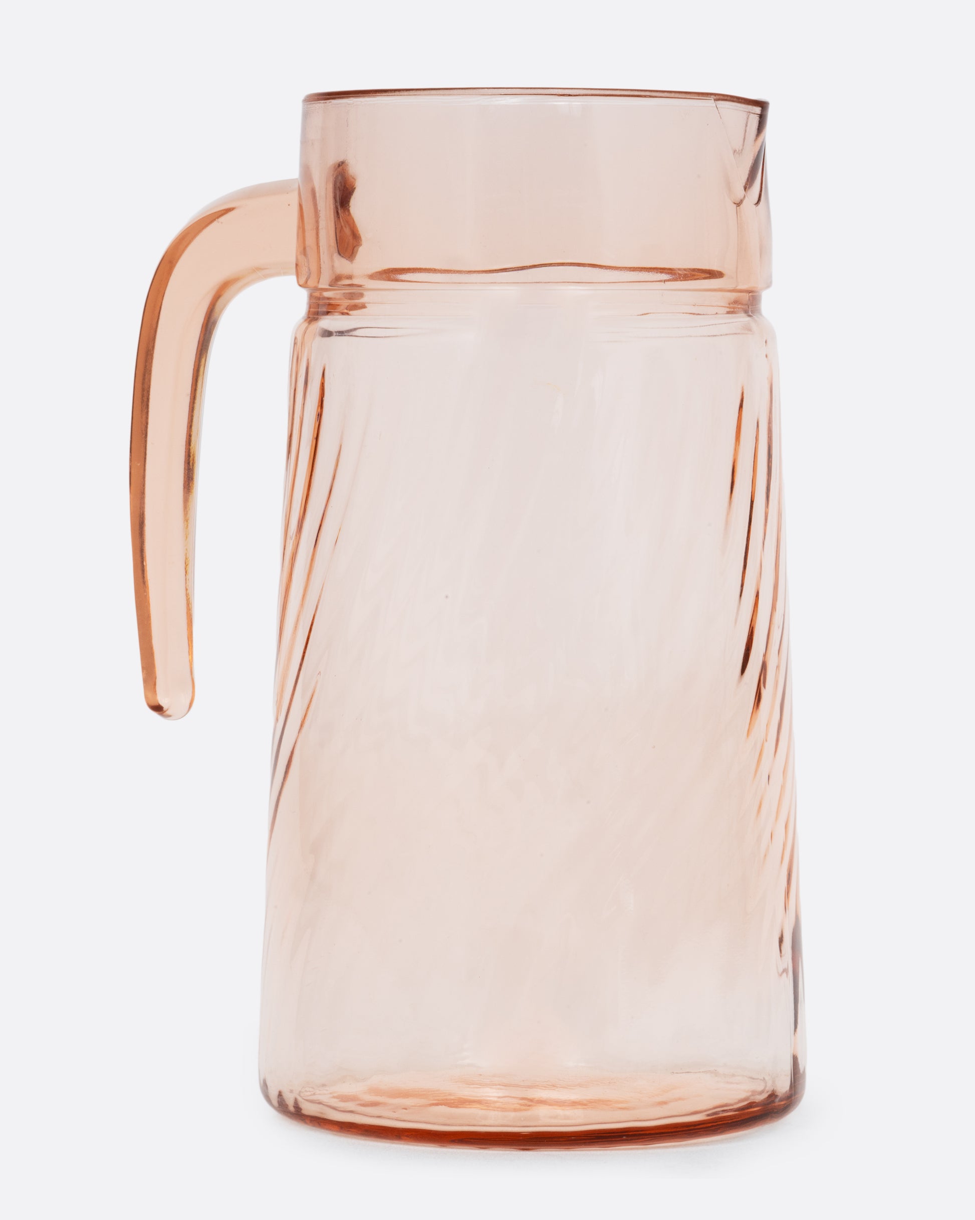 A pale pink glass pitcher with a twisted texture and sleek handle. Shown from the side.