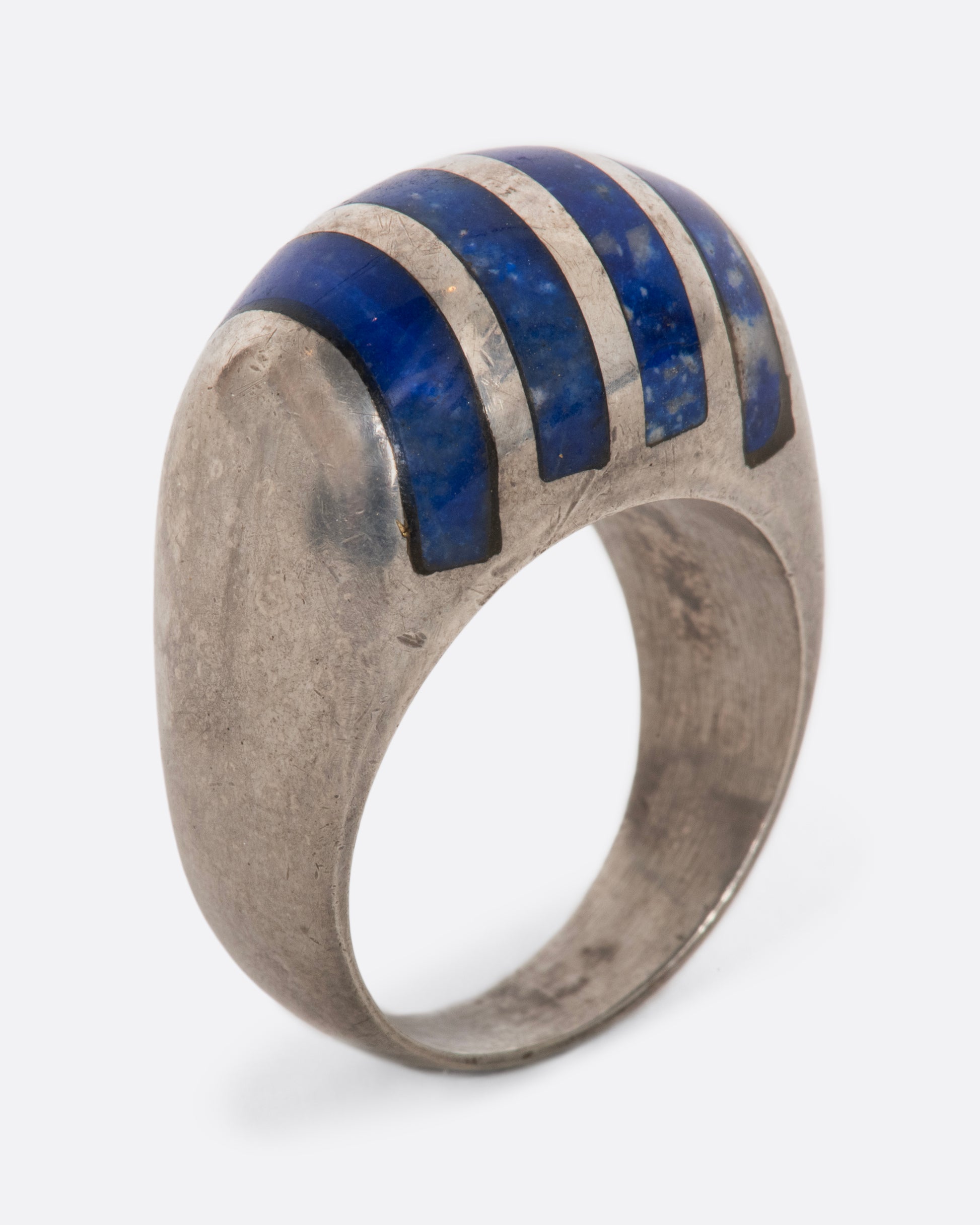 A sterling silver ring with four lapis sections. View standing up.