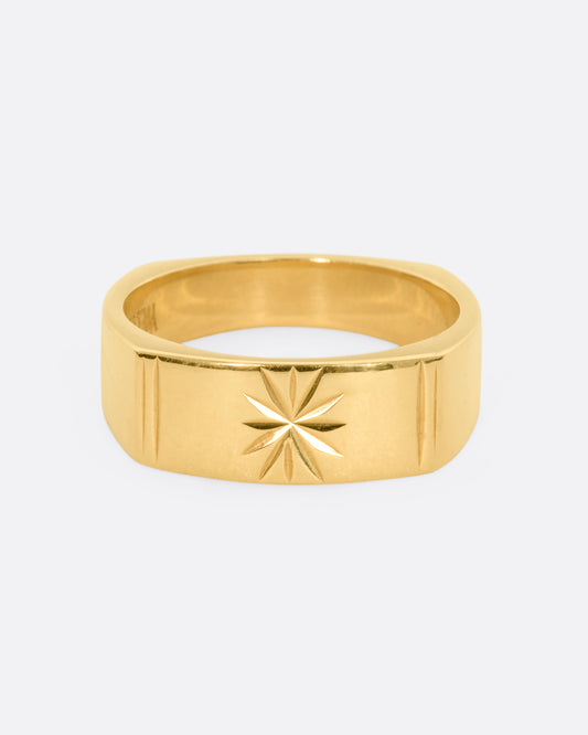 A yellow gold squared band with a star etching on the front. View from the front.