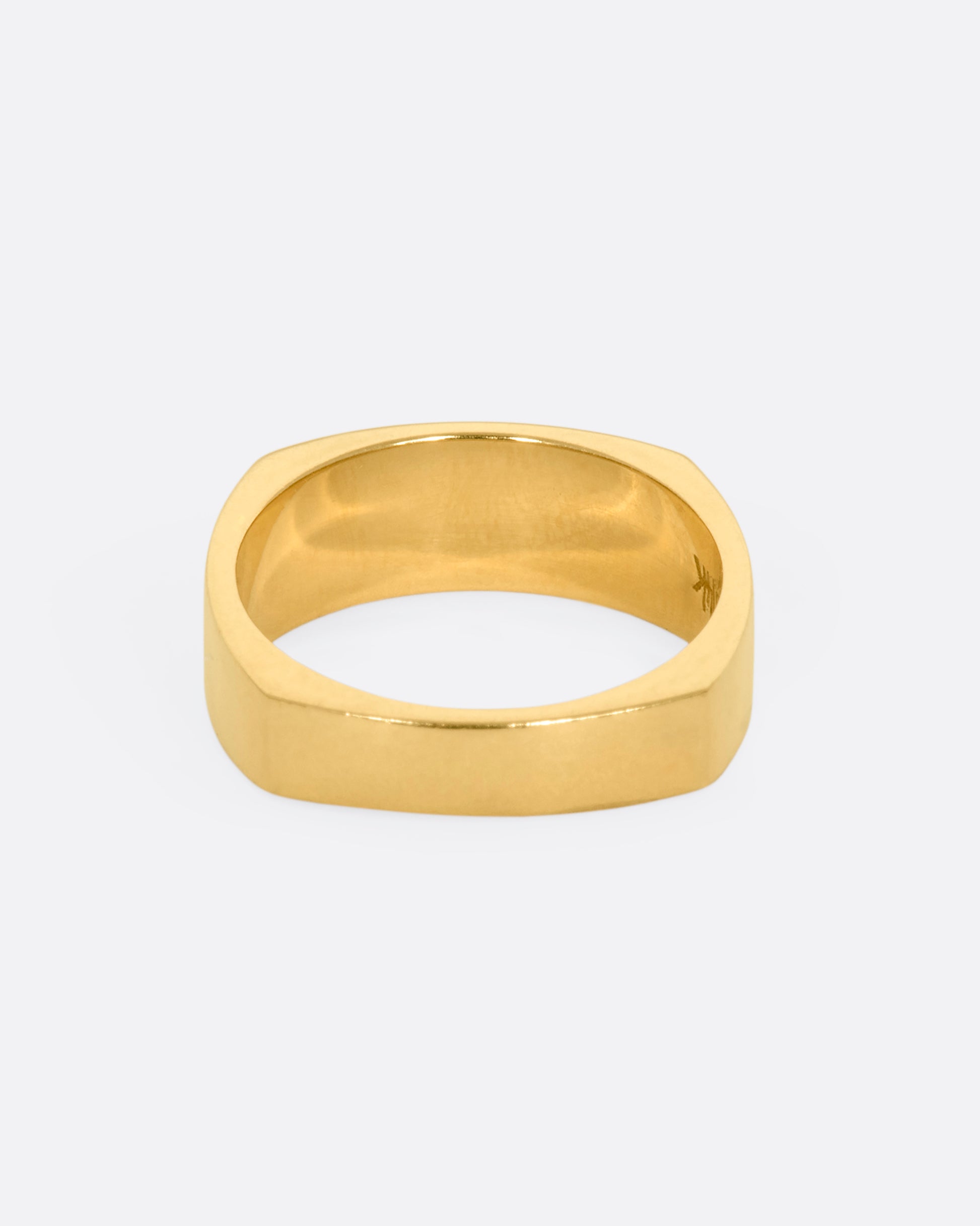 A yellow gold squared band with a star etching on the front. View from the back.