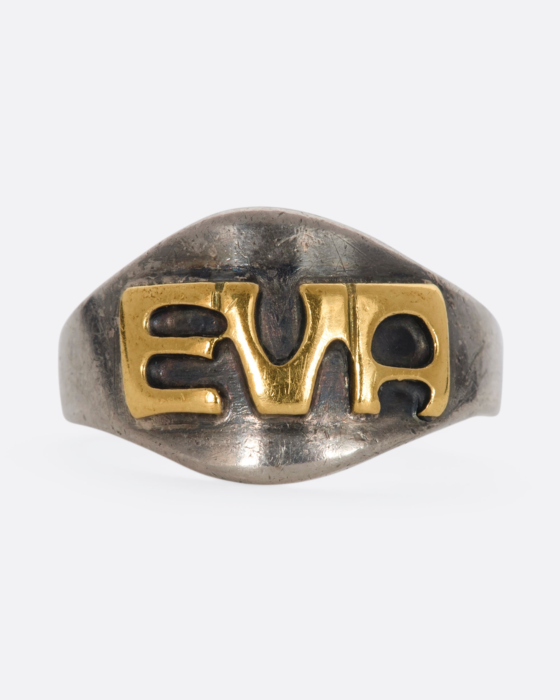 A sterling silver signet ring with the letters "EVA". View from the front.