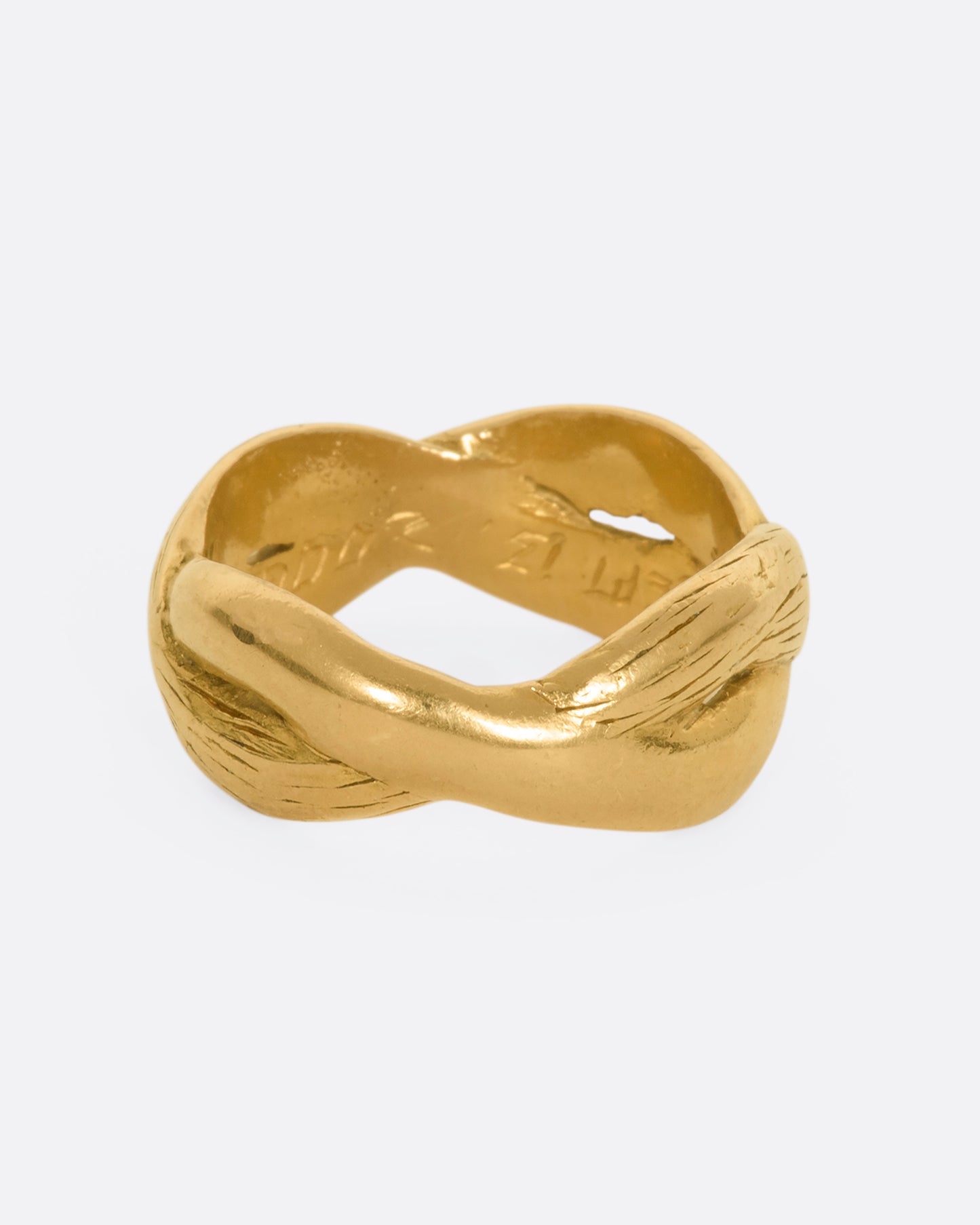 A yellow gold twisted band with engraving.