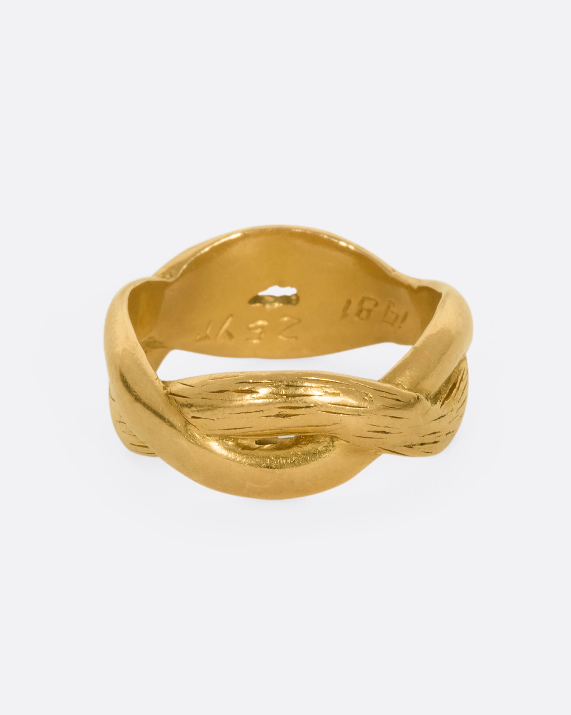 A yellow gold twisted band with engraving.