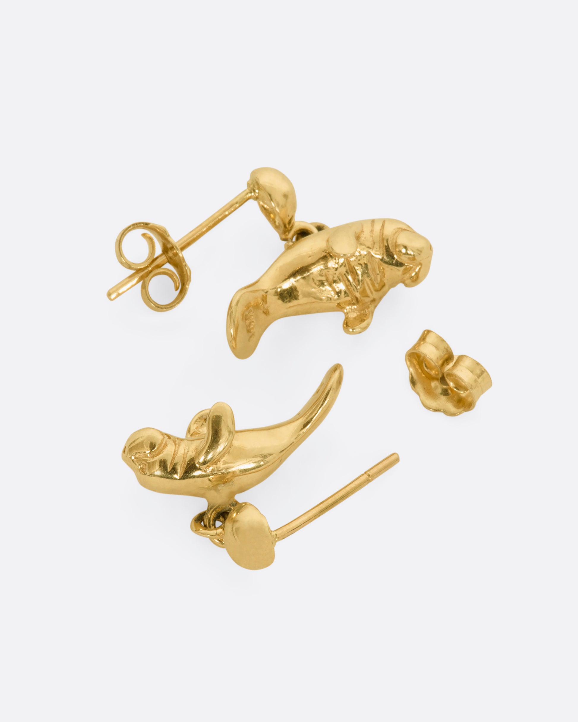 Yellow gold manatee drop earrings. View laying flat.