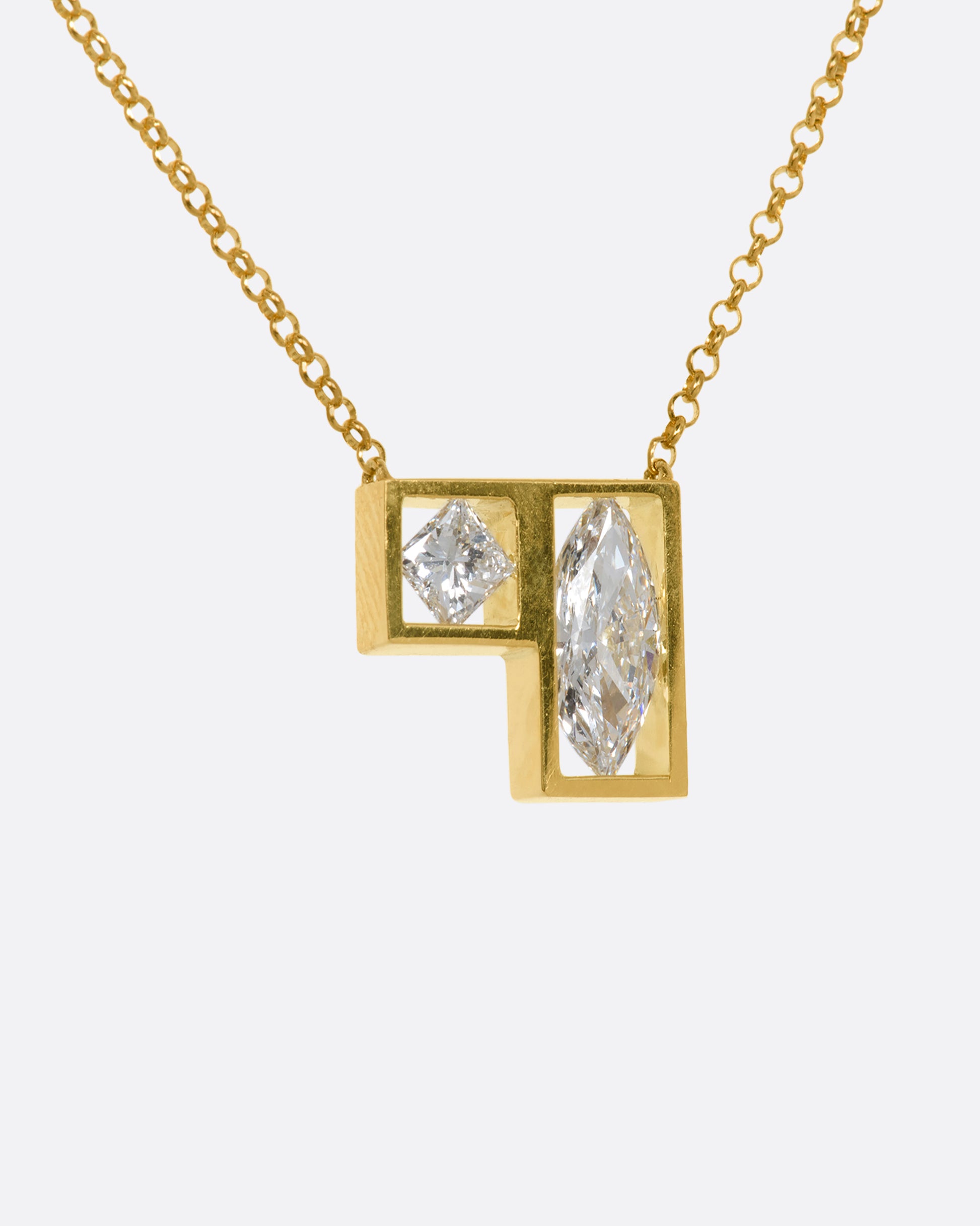 A yellow gold square and rectangle frame fixed pendant hold a marquise and a princess cut diamond hanging from a chain. View from the side.