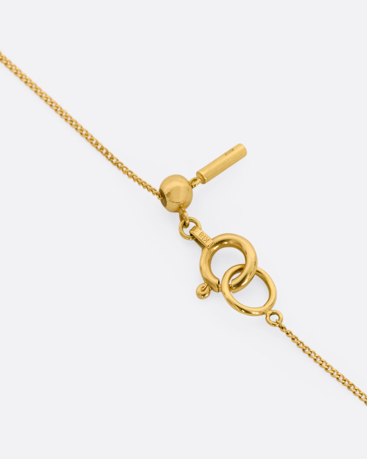 A yellow gold square fixed pendant frame holds a rose cut diamond slice hanging from a chain. View up close of the clasp.