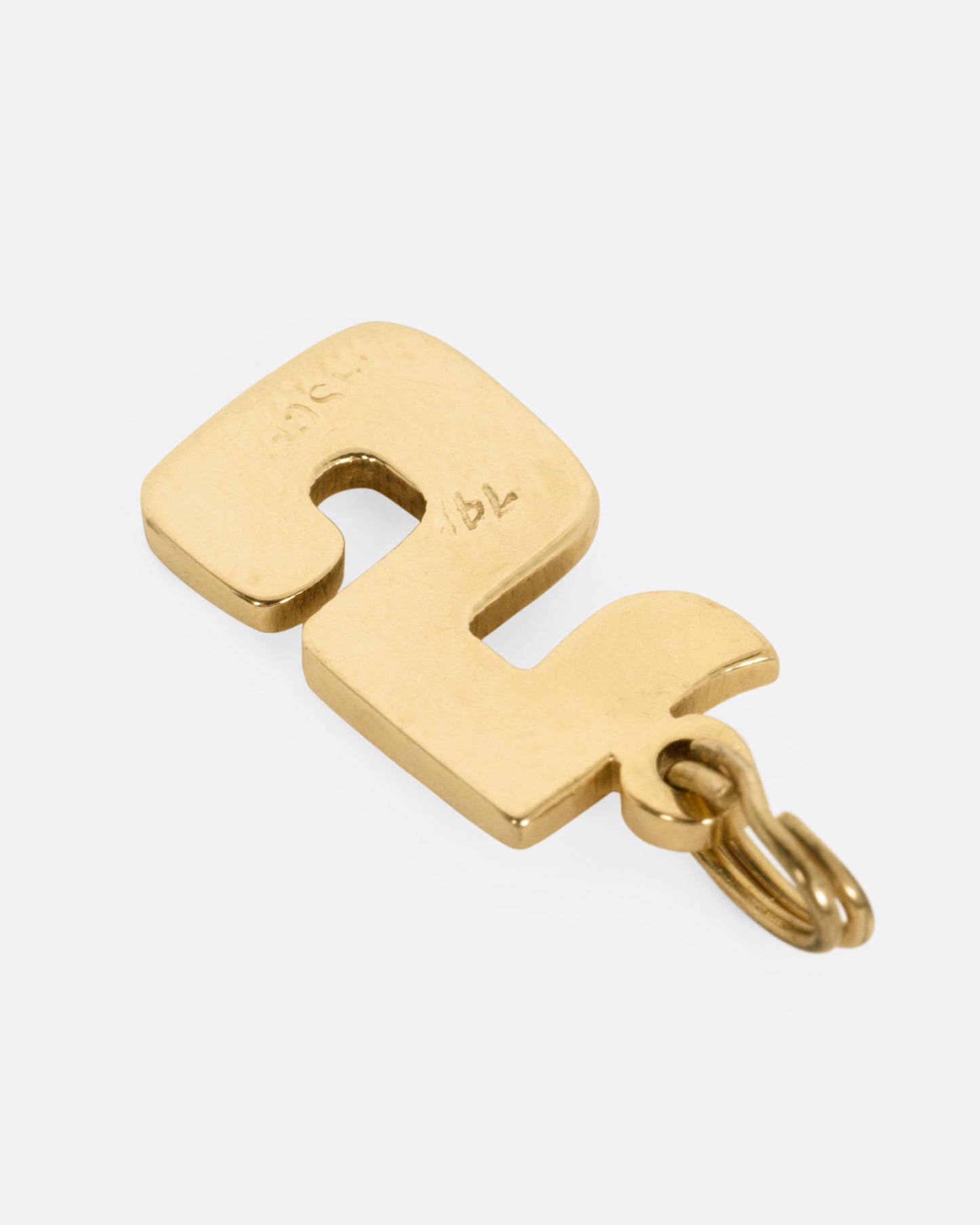 A yellow gold 5 charm, shown from the back.