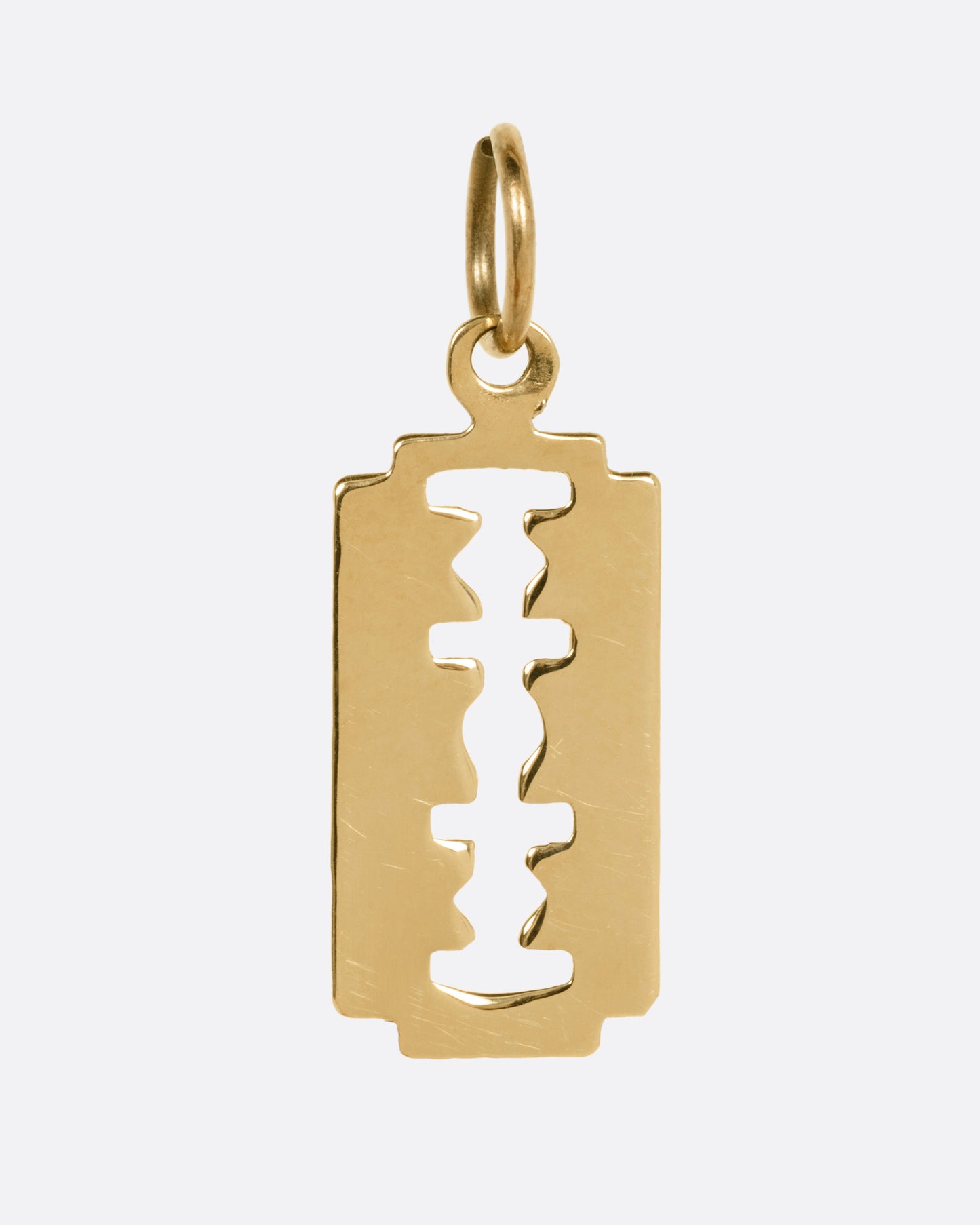 A yellow gold razor blade charm, shown from the front.