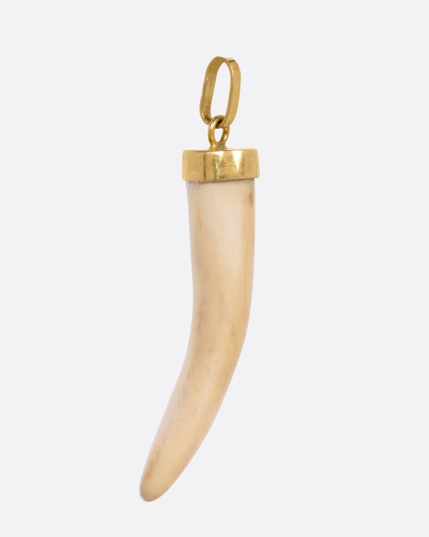 A horn shaped one charm with a yellow gold bail, shown from the side.