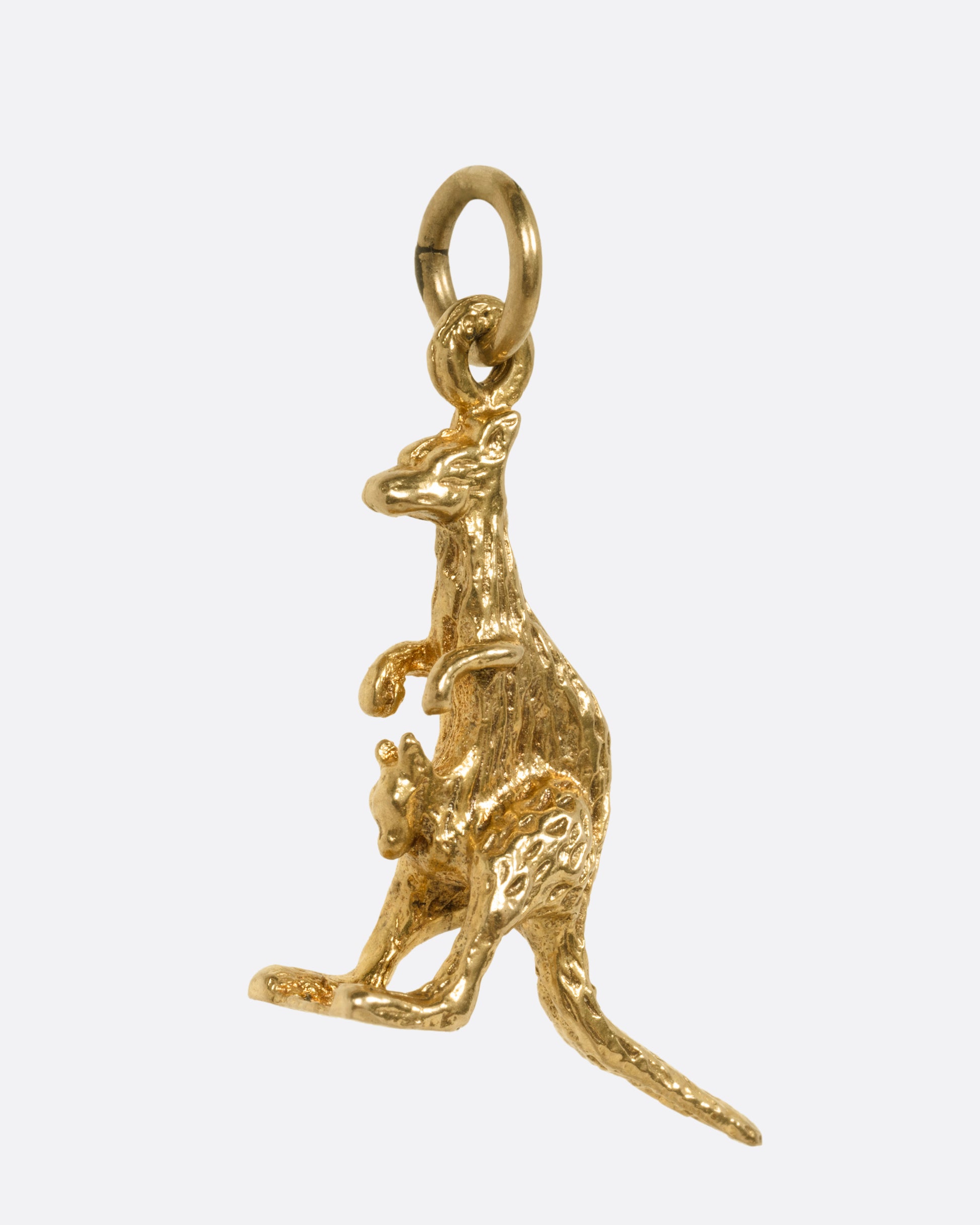 A yellow gold kangaroo and baby joey pendant, shown from the side.