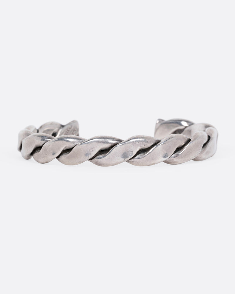 A silver twisted cuff bracelet, shown from the front.