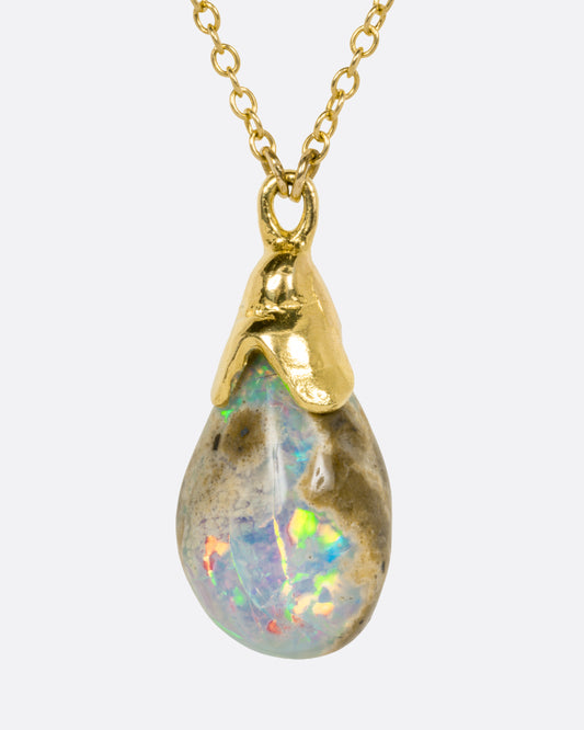 A yellow gold necklace with a teardrop shaped opal pendant, shown from the front.