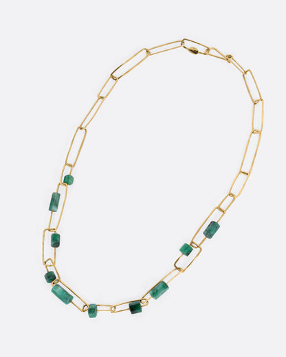 A yellow gold paperclip chain necklace with emerald beads, shown from the front.