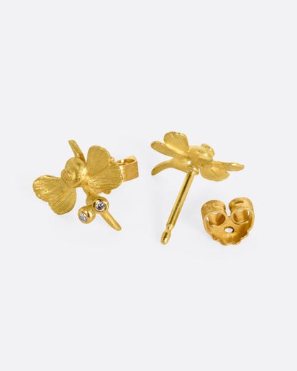 A pair of yellow gold hummingbird stud earrings with diamond eyes. One earring is shown from the front, the other is open from the back.
