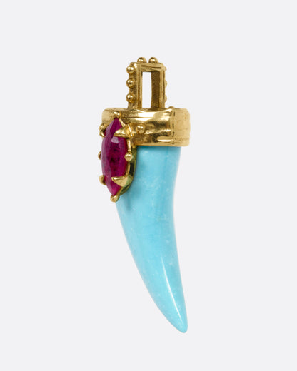 A yellow gold pendant with a sleeping beauty turquoise horn and a marquise ruby, shown from the side.