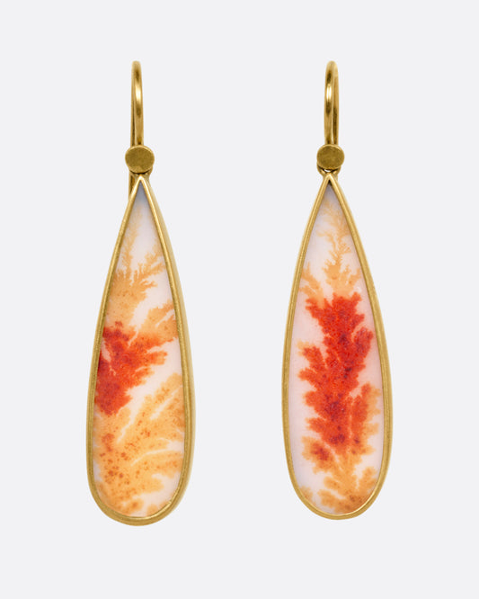 A pair of pear shaped dendritic agate drops in 18K gold bezel settings, shown from the front.