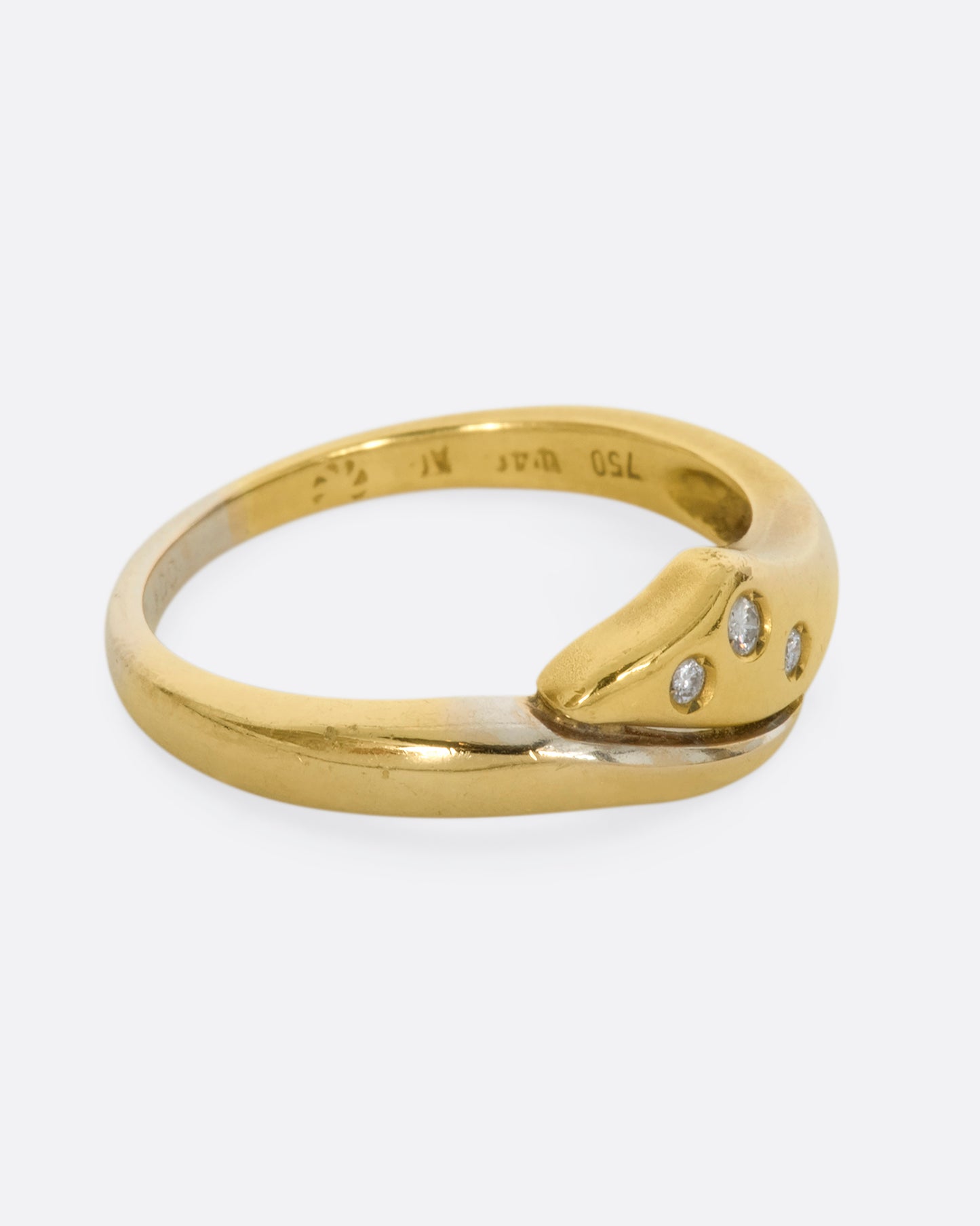 A yellow and white gold wrap ring with three diamonds. Shown from the side.