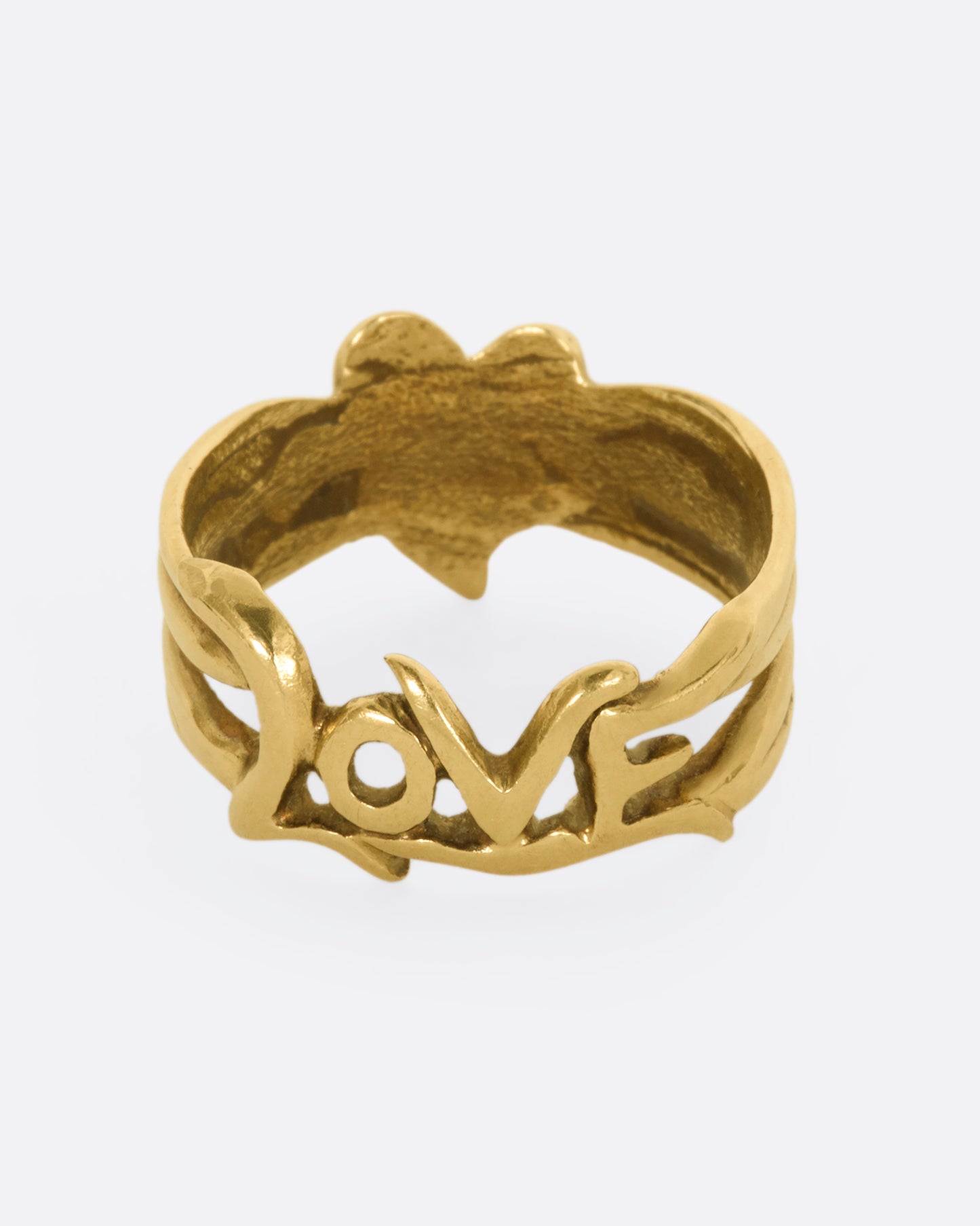 Yellow gold band with a heart on one side and 'Love' written on the other side. View of the love side.