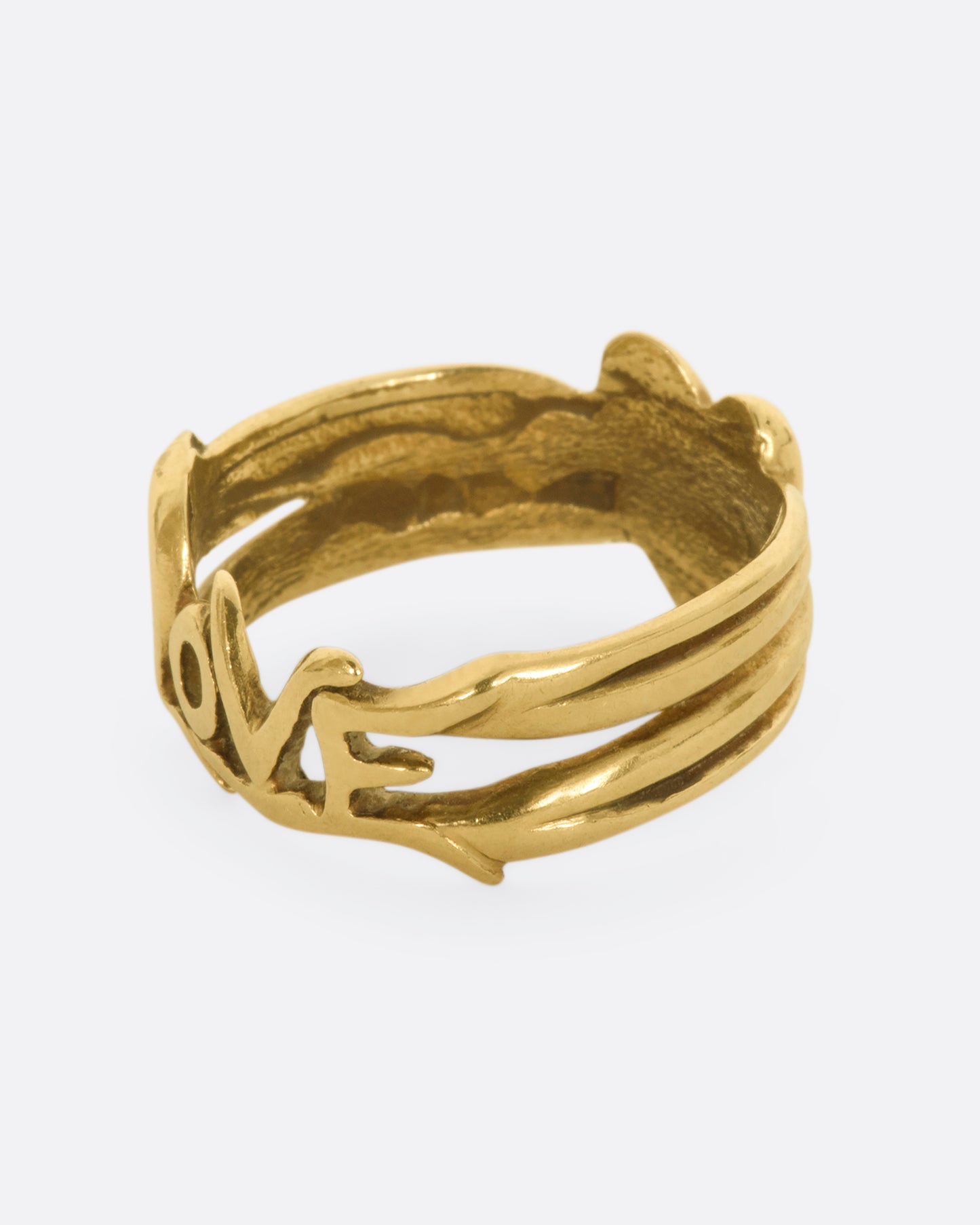 Yellow gold band with a heart on one side and 'Love' written on the other side. View of the side.