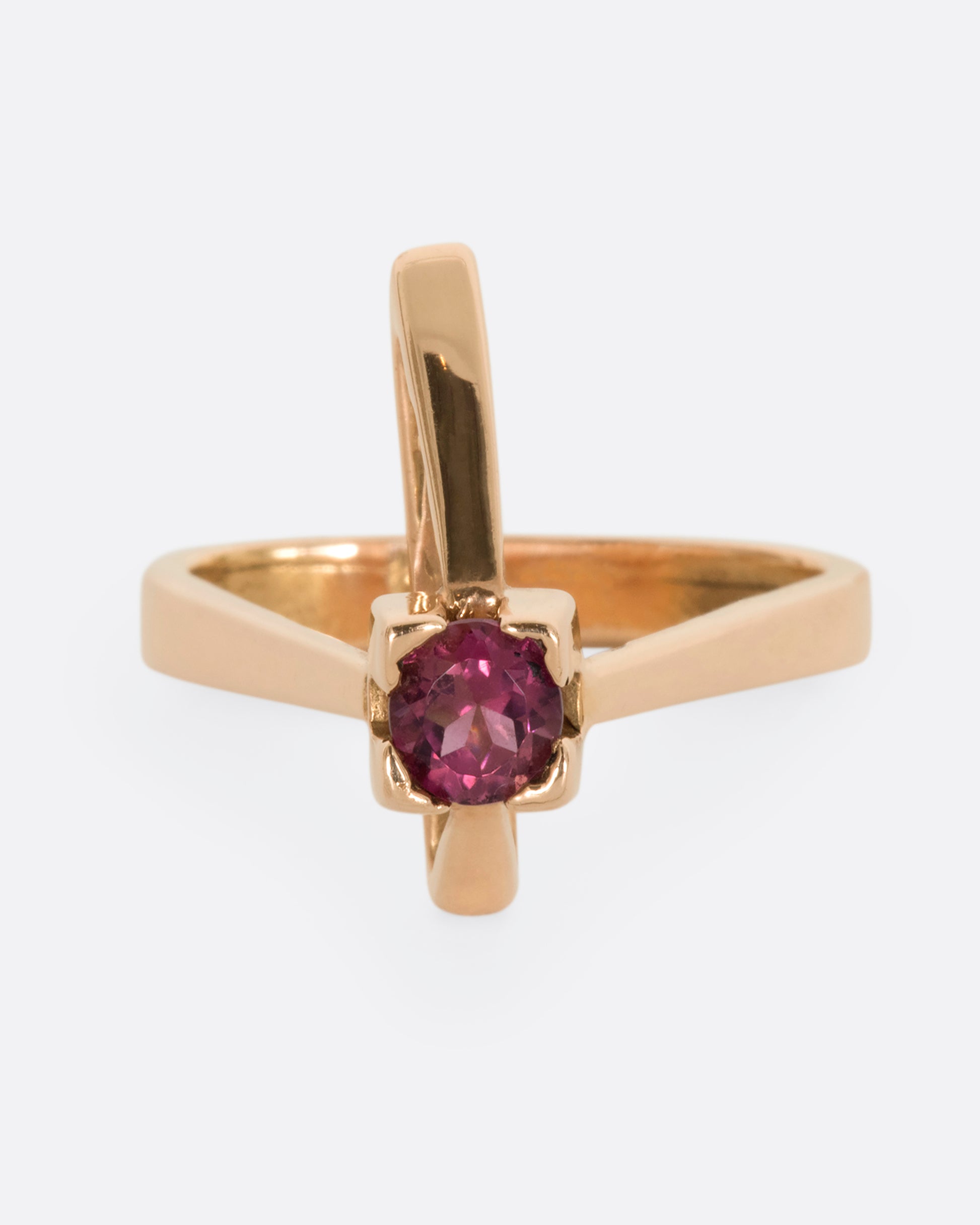 A geometric rose gold ring with a prong set pink tourmaline. Shown from the front.