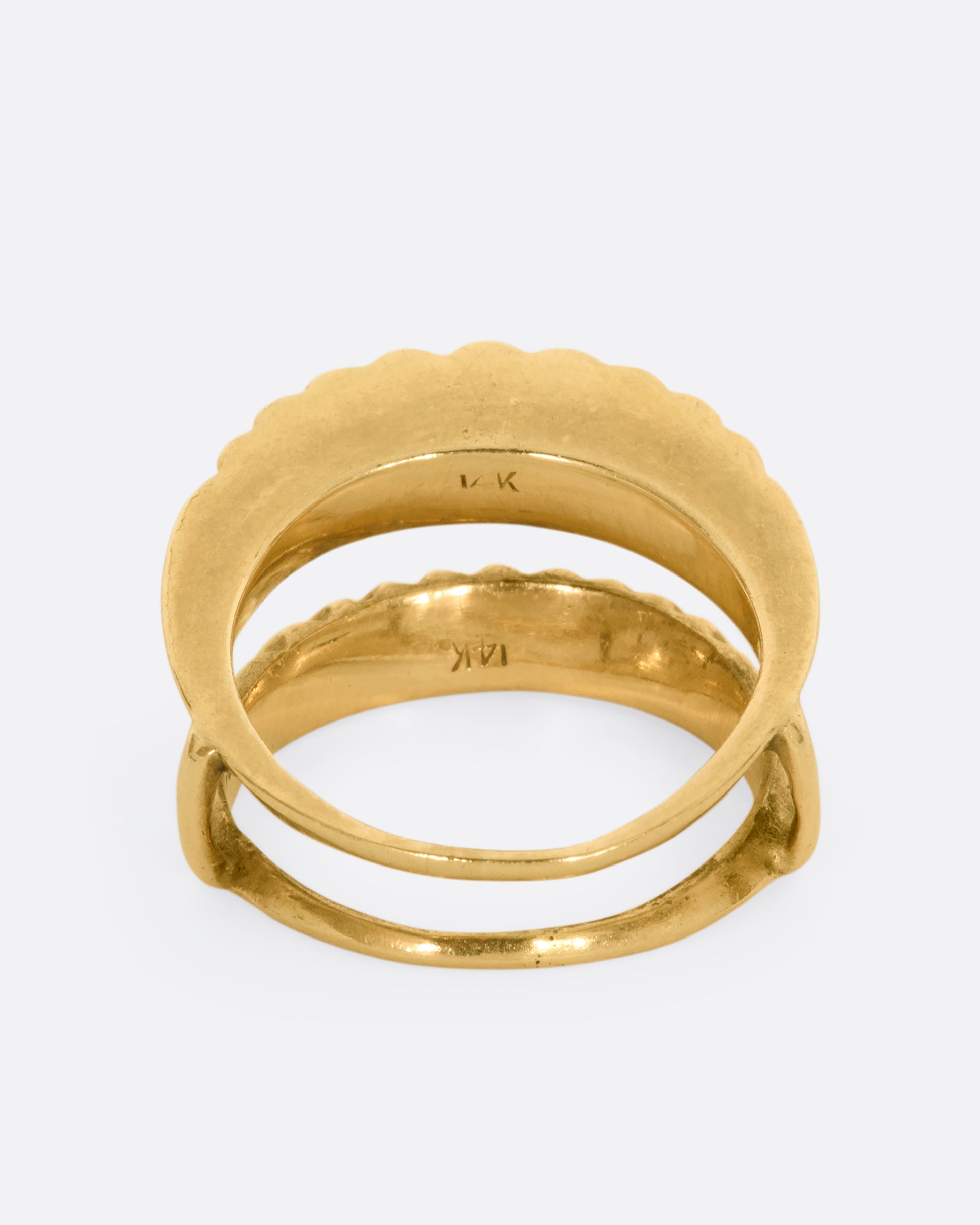 A yellow gold guard ring with a scalloped edge. Shown from the back.