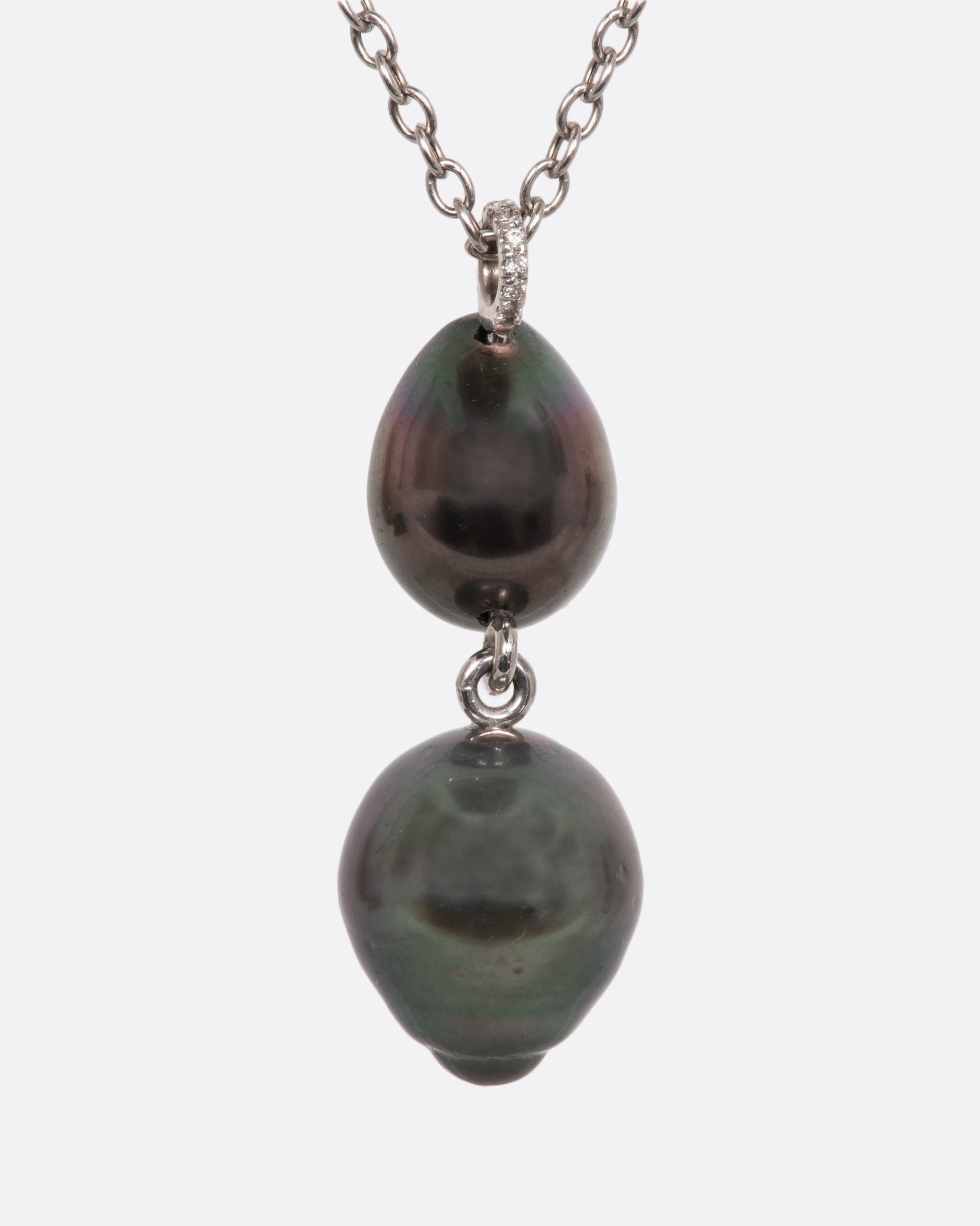 A white gold necklace with a double tiered Tahitian pearl pendant lined with black and white diamonds and a pave diamond bail. View from the back.