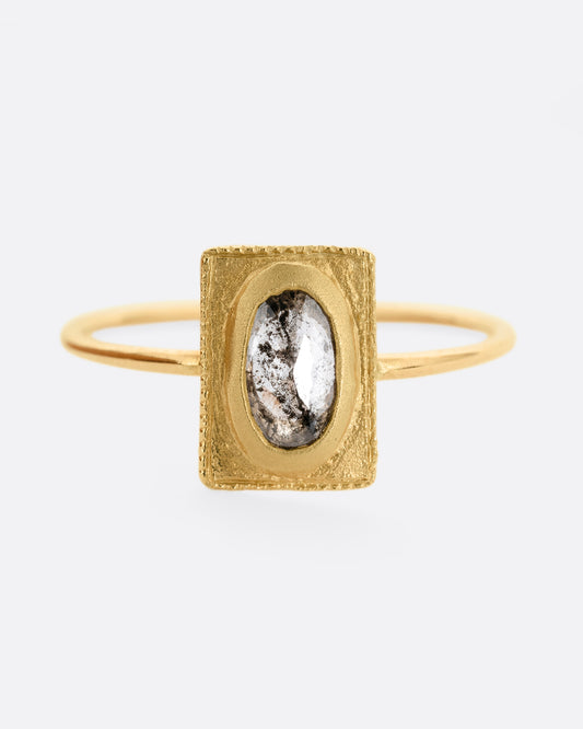 A yellow gold ring with an oval rose cut diamond in a rectangular setting. Shown from the front.