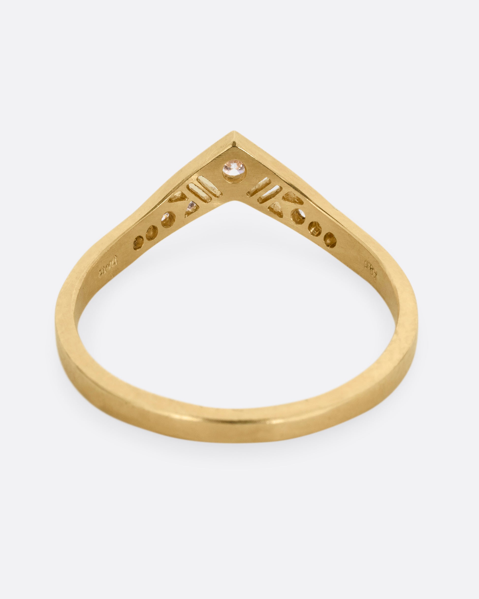 A slightly pointed yellow gold ring with diamonds and cutouts shown from the from the back.