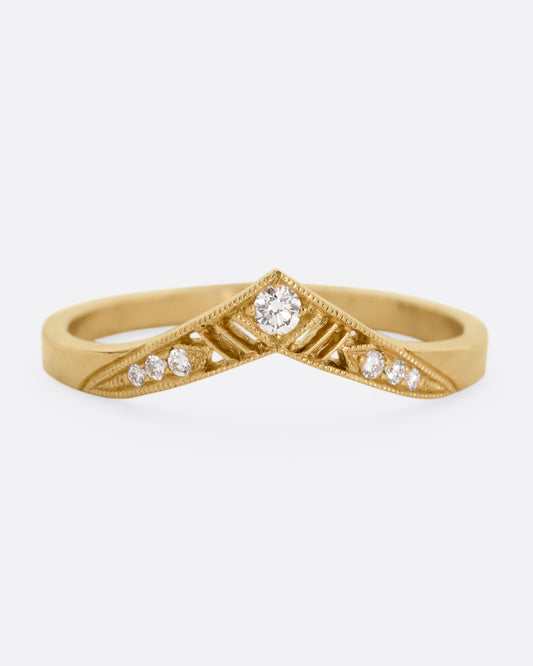 A slightly pointed yellow gold ring with diamonds and cutouts shown from the from the front.