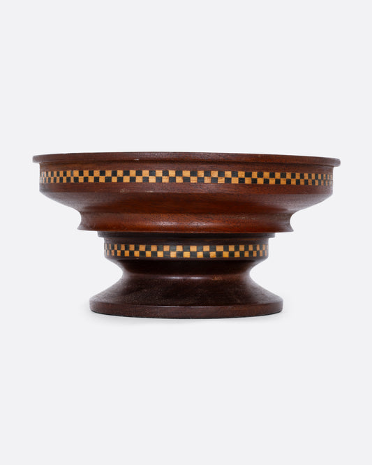 A wooden hand turned bowl with a checkerboard inlay and felted bottom. Shown from the front.