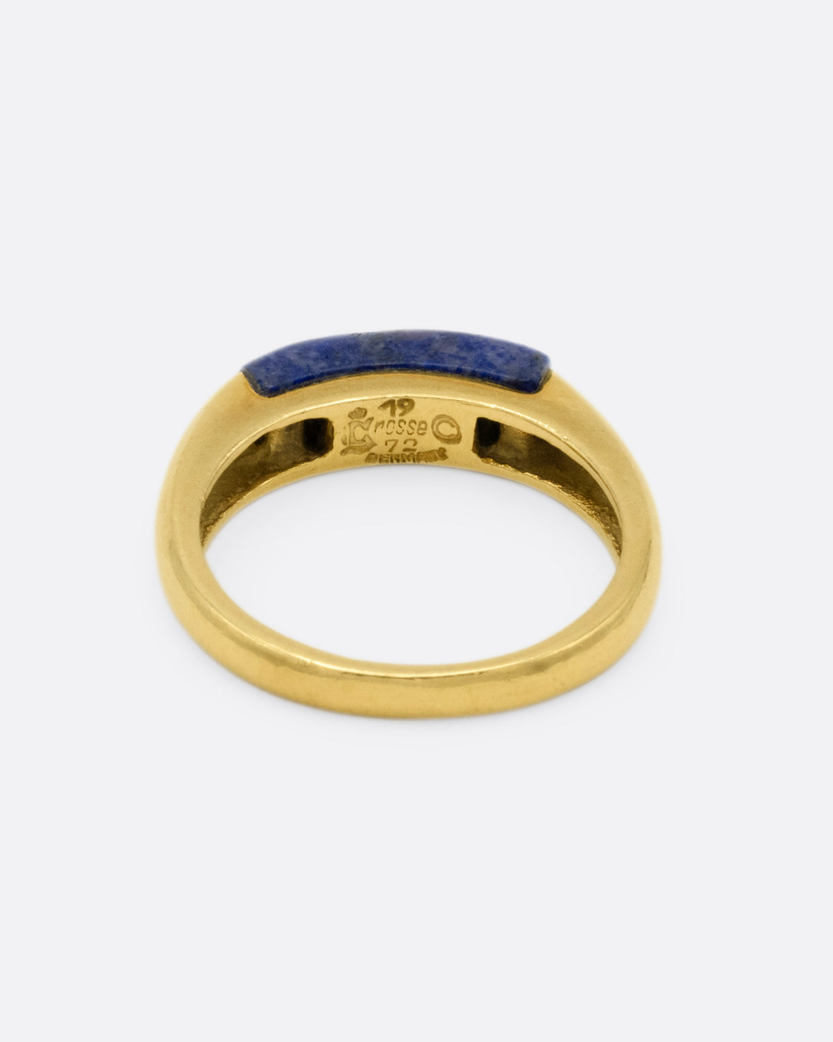 A yellow gold signet ring with a rounded silhouette and bar of lapis, shown from the back.