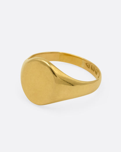 A yellow gold signet ring, shown from the side.