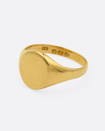 A yellow gold signet ring, shown from the side.