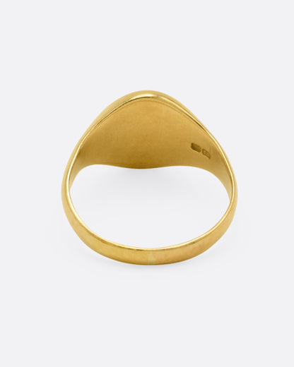 A yellow gold signet ring, shown from the back.