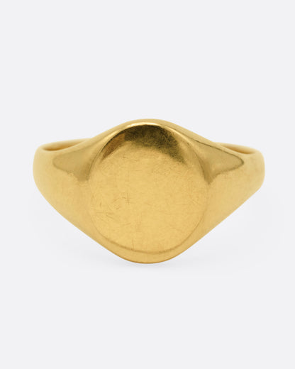 A yellow gold signet ring, shown from the front.