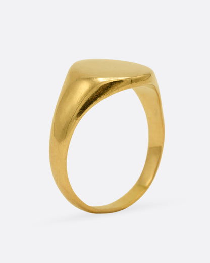 A yellow gold signet ring, shown from the side standing up.