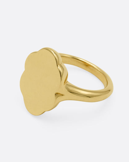 A yellow gold signet ring with scalloped edges, shown from the side.