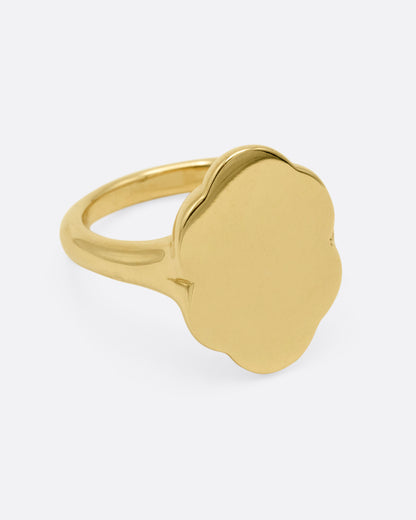 A yellow gold signet ring with scalloped edges, shown from the side.