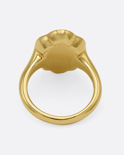 A yellow gold signet ring with scalloped edges, shown from the back.