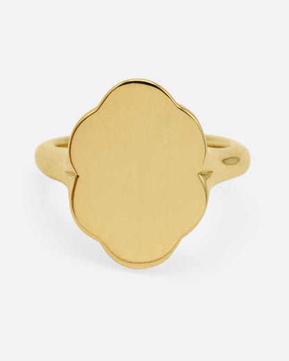 A yellow gold signet ring with scalloped edges, shown from the front.