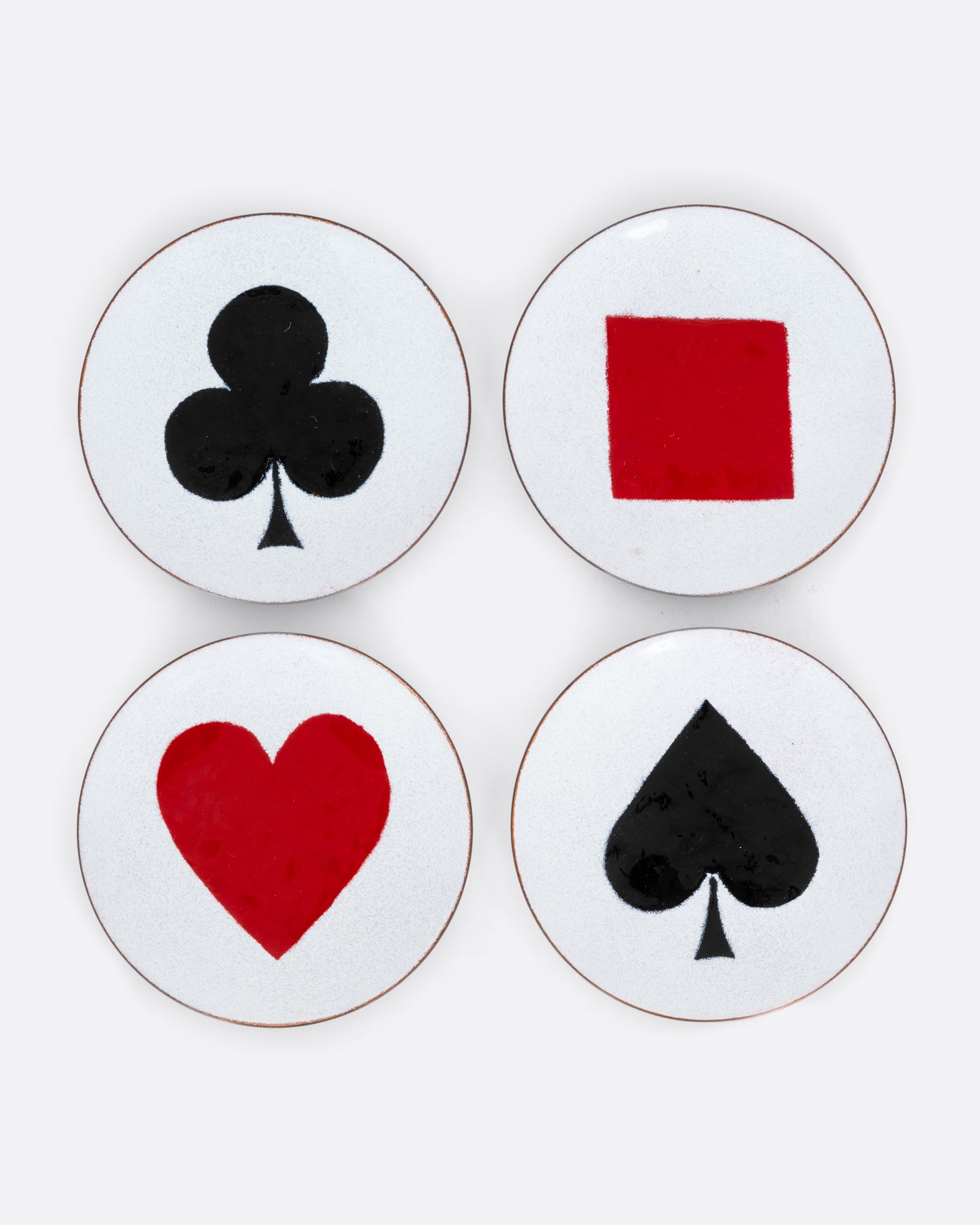 A set of four enamel plates with playing card suits, shown from the top.