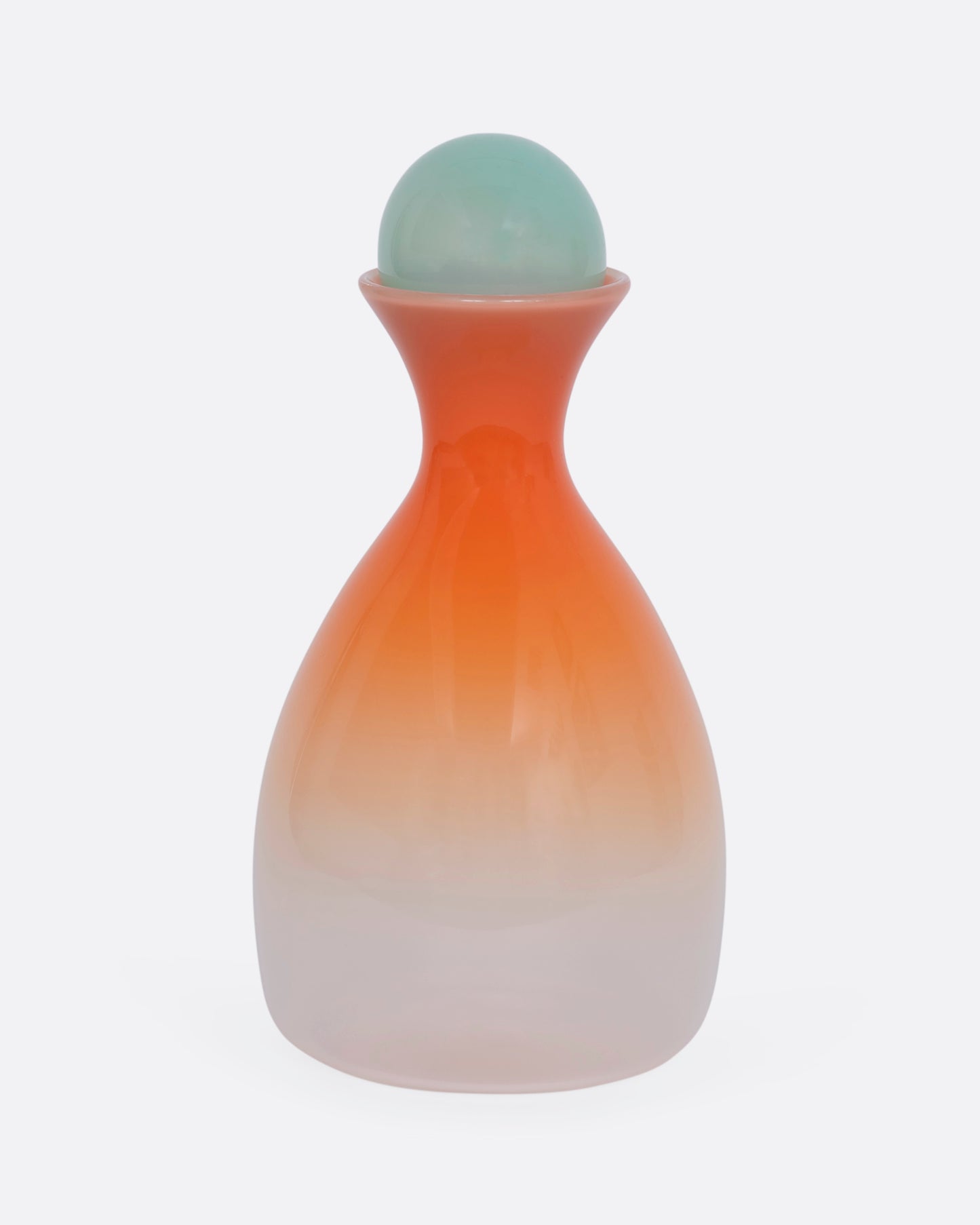 An ombre orange decanter with a mint green sphere stopper. View from the front.