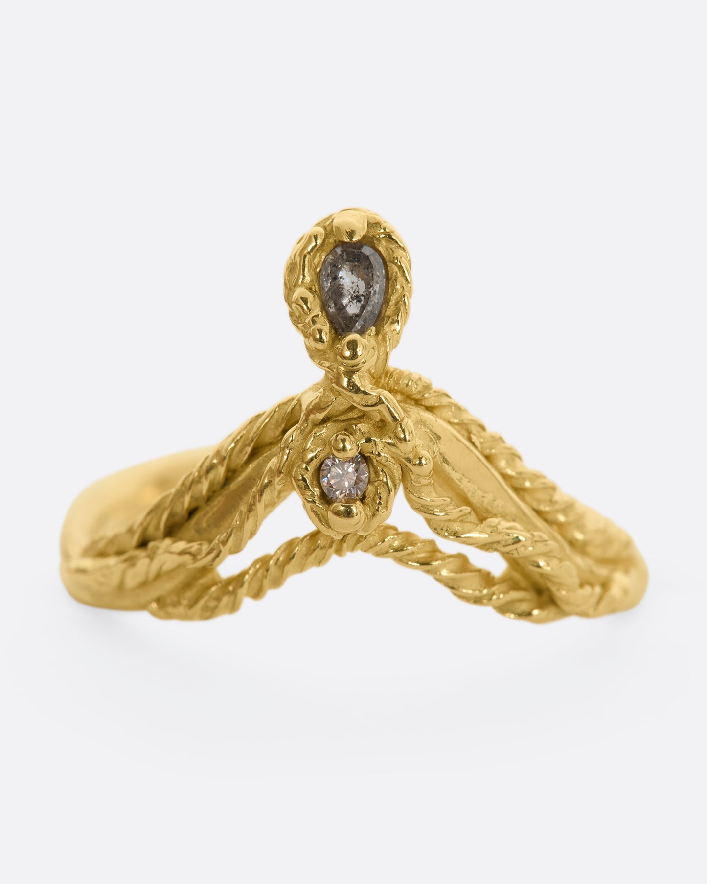 A yellow gold tiara shaped ring with twisted gold details, a rose cut salt and pepper tear drop diamond and a brilliant cut champagne diamond. Straight on view from the front.