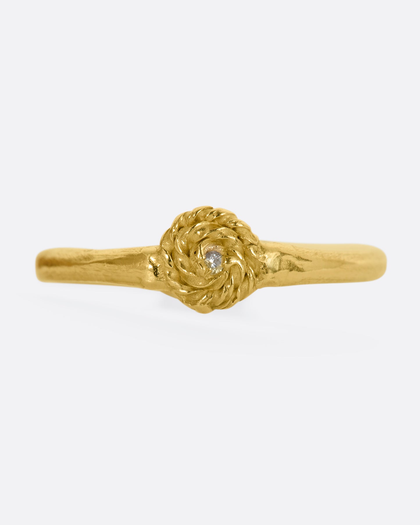 A yellow gold ring with a rosebud motif on either side, one with a white sapphire, the other with a blue sapphire for wear two ways. View of the white sapphire side, straight on.